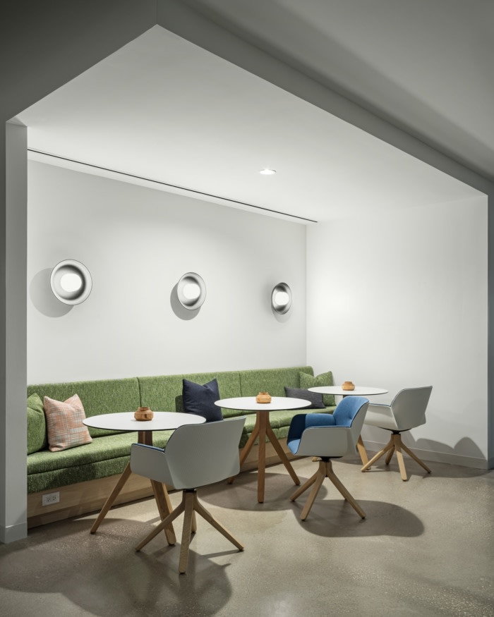 Indeed Austin seating nook with a green banquette and round tables